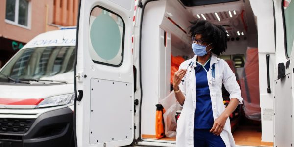 african-american-female-paramedic-face-protective-medical-mask-standing-front-ambulance-car_627829-4899
